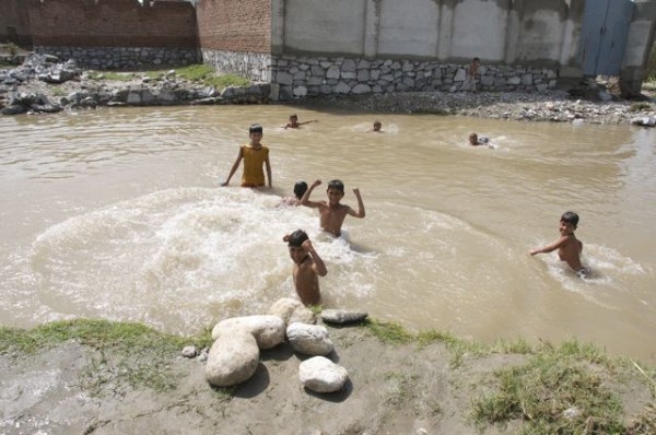 Local kids playing in a pool created by the flood waters