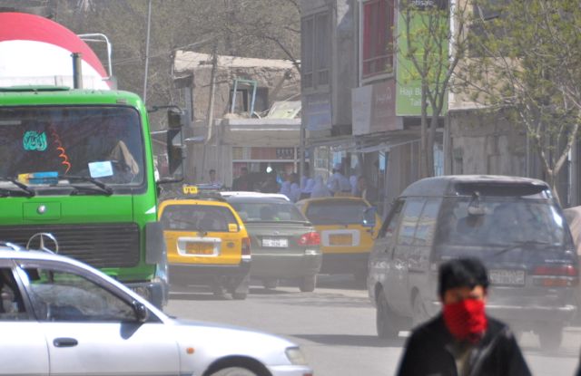 The fighting is one block over to the right as you look down the street in this picture. The traffic is pretty light but has not stopped as people try to get around the police barricades that have isolated the attackers. You can't see them but there is a group of school girls clustered at the corner at the right end of the street peering down the road towards the fighting - the ANP escorted them down the road a bit after this photo was taken. A steel tornado is ravaging the downtown just a few hundred meters away while these local people are trying to find their way home. People can adopt to most anything